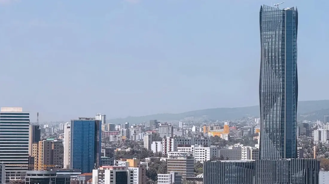 Skyline of Addis Ababa, Ethiopia, with a tall glass tower, city buildings and a road below